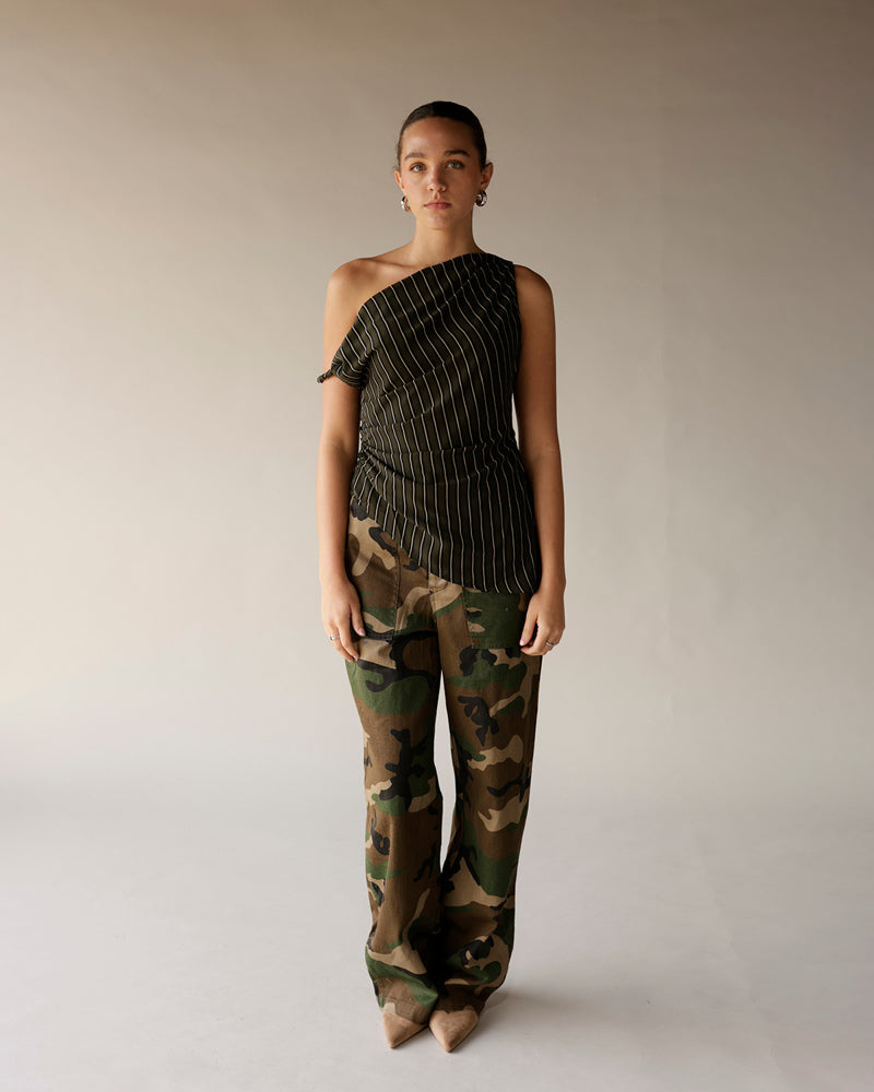 Women's black pinstripe one-shoulder ruched top paired with camo wide-leg pants