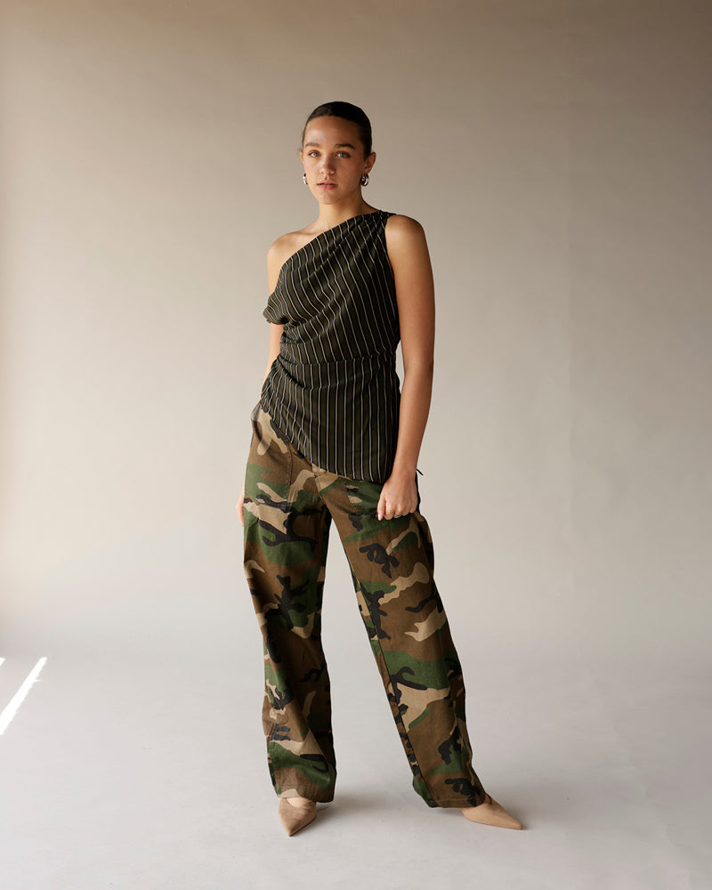 Olive pinstripe one-shoulder ruched top paired with camo cargo pants