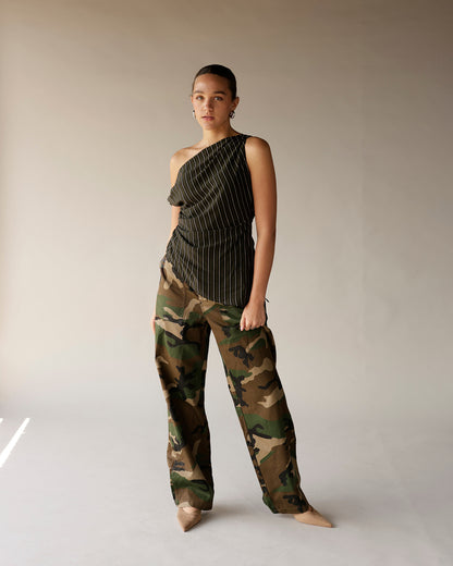 Olive pinstripe one-shoulder ruched top paired with camo cargo pants