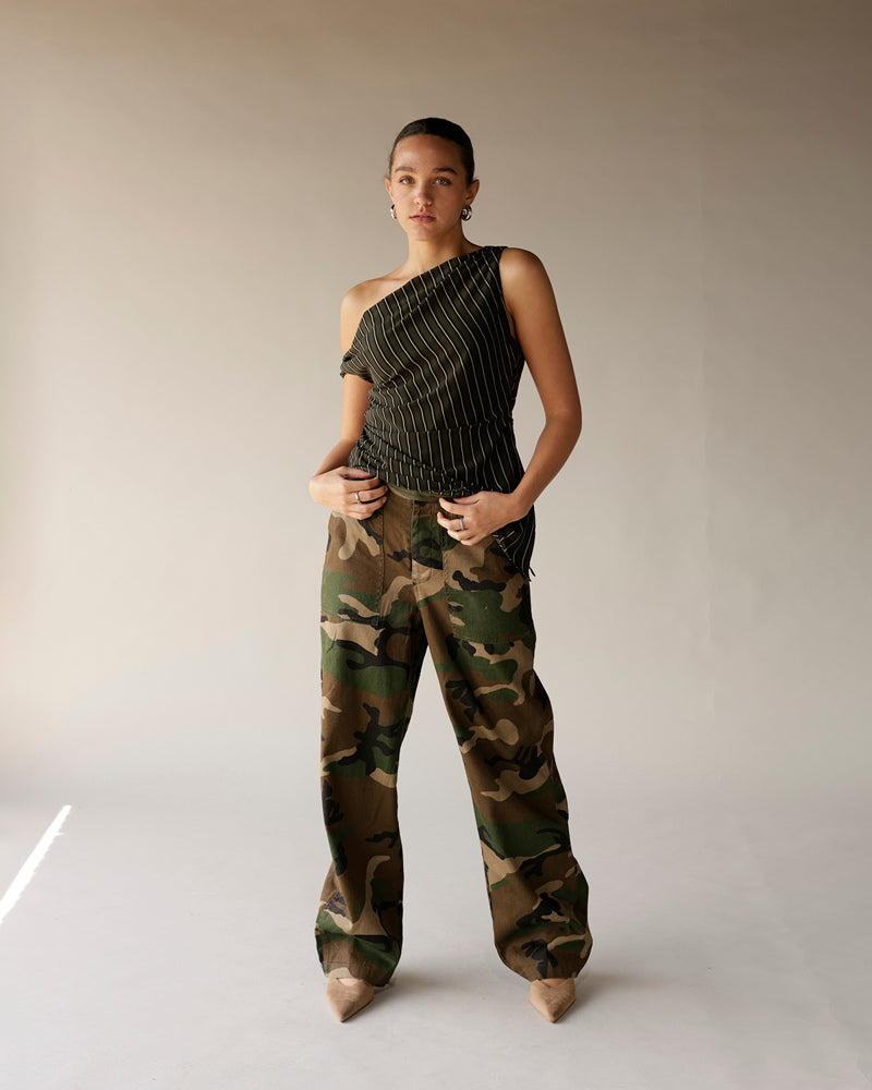 Women's black pinstripe one-shoulder ruched top paired with camo wide-leg pants