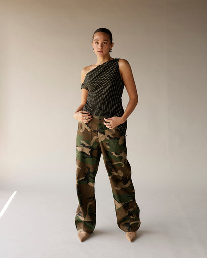 Women's black pinstripe one-shoulder ruched top paired with camo wide-leg pants