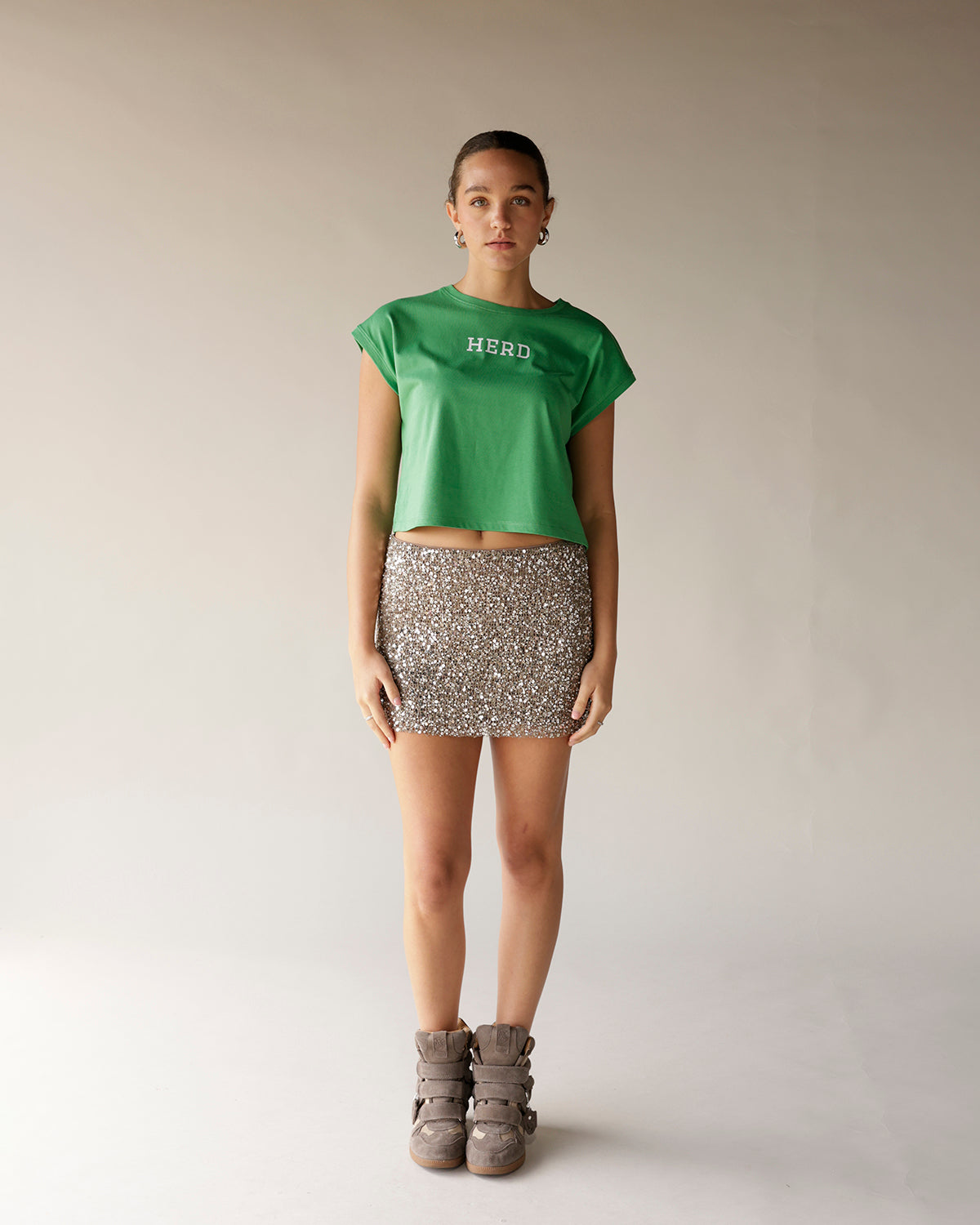 Kelly green cropped muscle tee with white HERD graphic text on chest