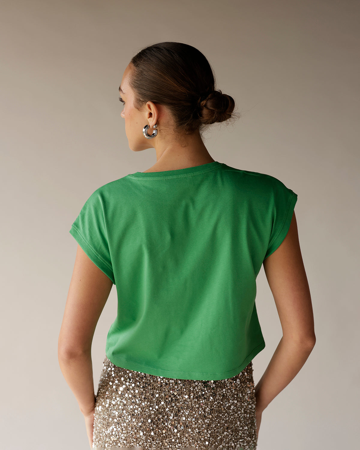Women's kelly green cropped muscle tee with rolled sleeves, back view