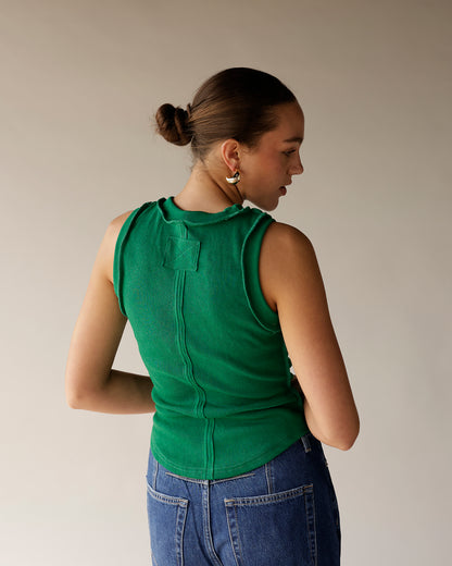 Green ribbed sleeveless tank top with back seam detail, worn with blue jeans