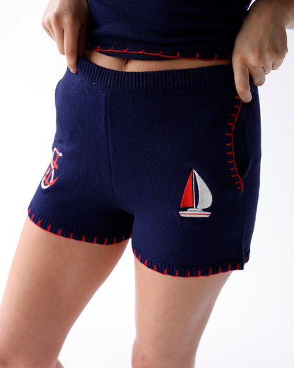 navy knit shorts with red embroidered details and anchor and sailboat patches