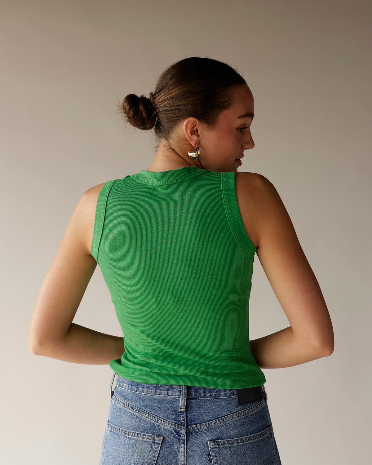 Kelly green ribbed sleeveless tank top, back view, paired with blue jeans