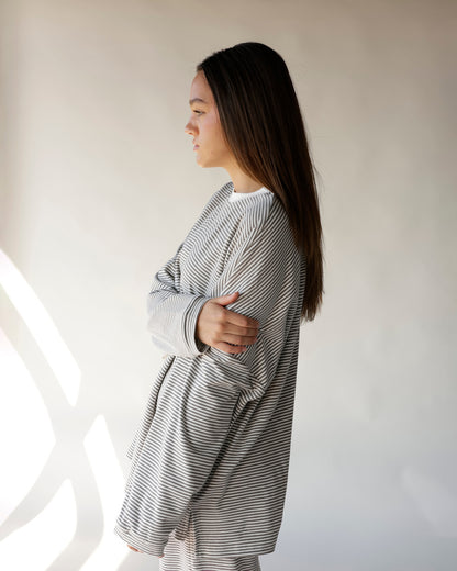 Gray and white striped long-sleeve lounge top worn by model, side view