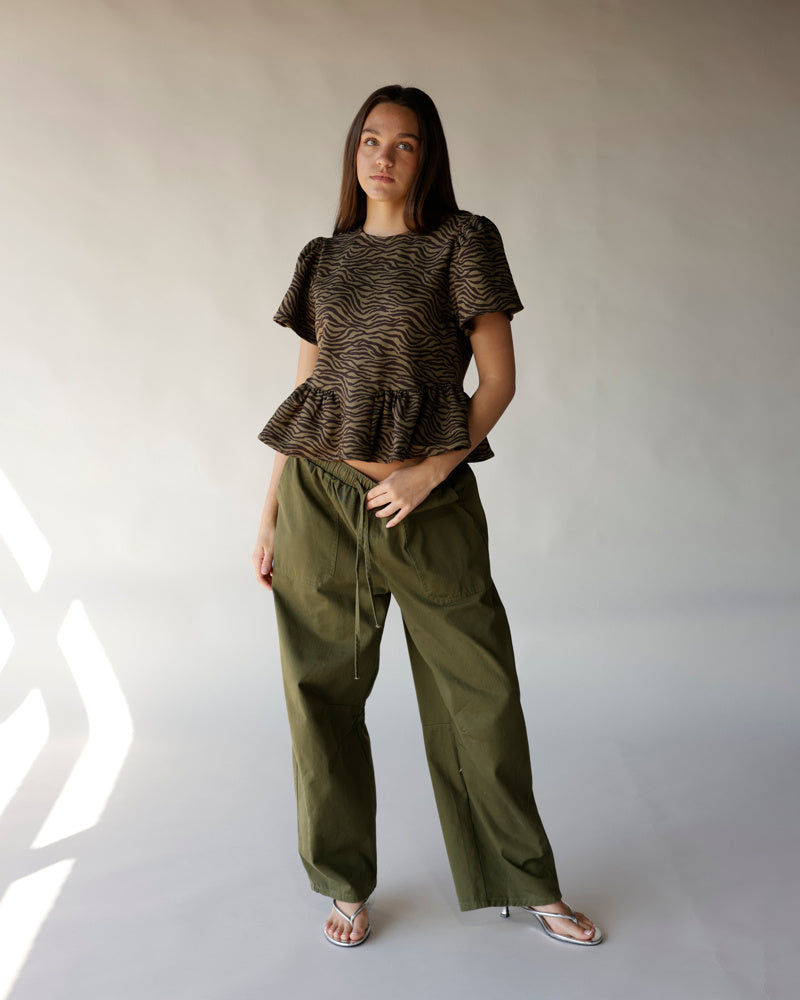 Olive zebra-print peplum top with short sleeves, paired with green cargo pants