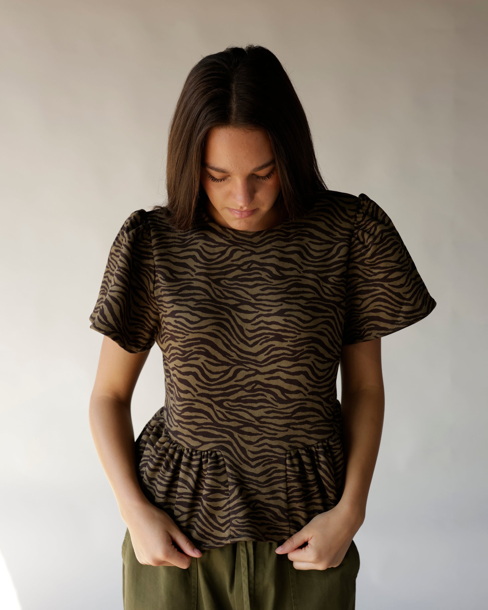 Brown and black zebra print peplum top with puff sleeves and ruffle hem