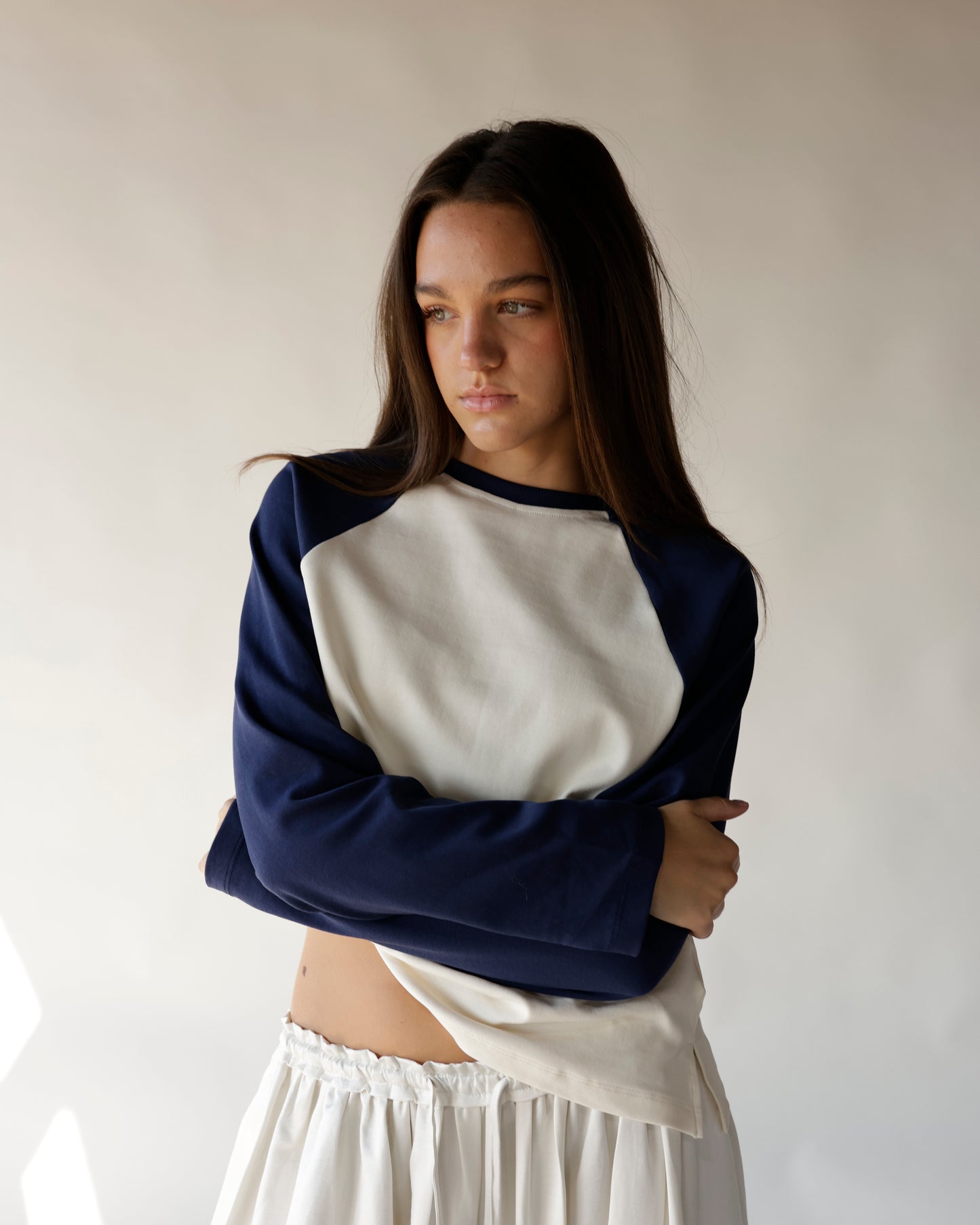 Navy and cream raglan sweatshirt with cropped fit, worn with white midi skirt