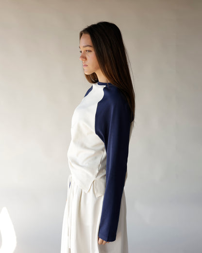 Navy and cream raglan long-sleeve top with color-block design, side profile view.