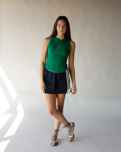 Black mini skirt with white stripe trim and tie details, styled with green tank top