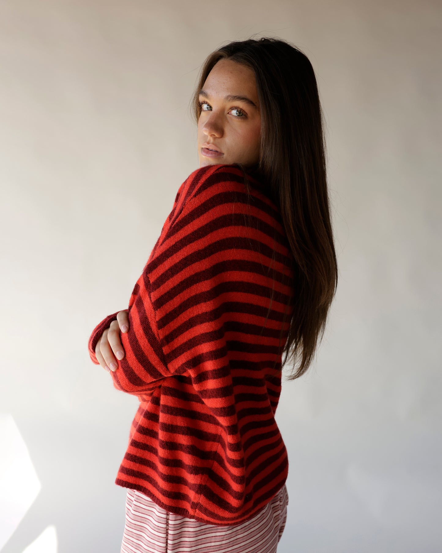 Red and burgundy striped mini mock neck sweater, oversized fit, worn by model