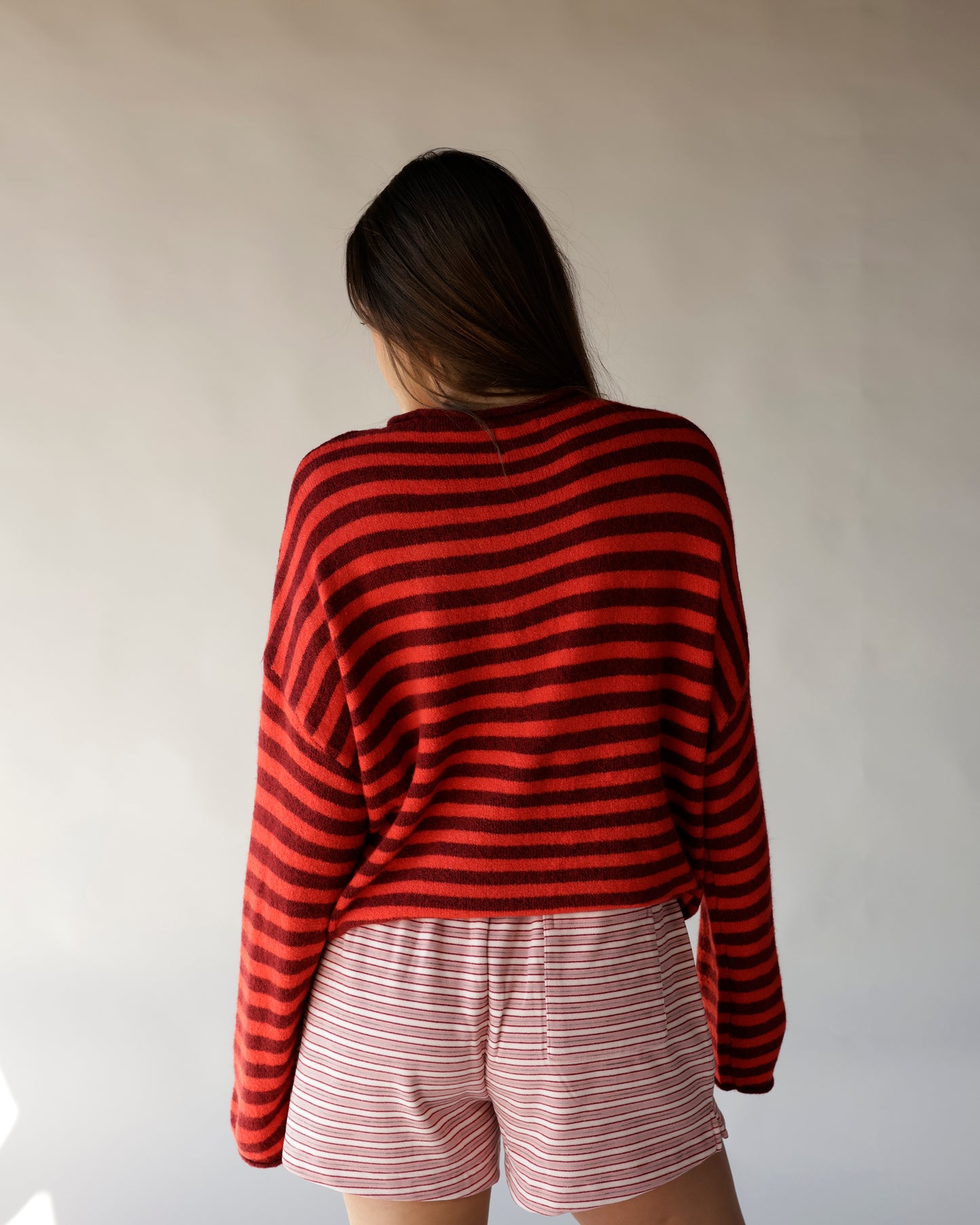 Red and burgundy striped knit mock neck sweater, back view, oversized fit