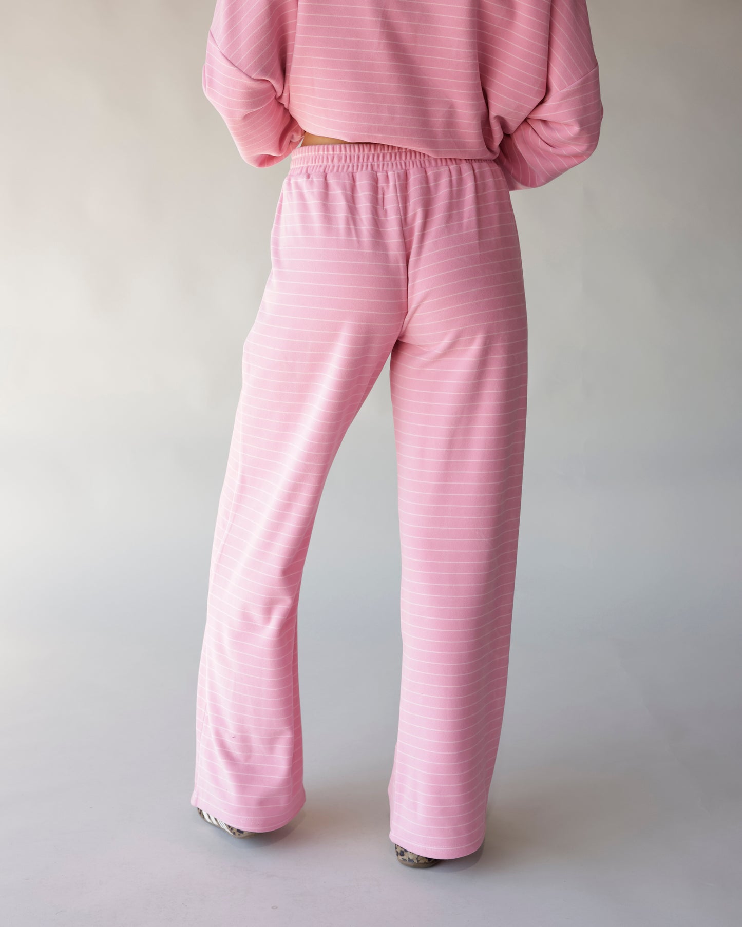 Pink striped wide-leg lounge pants with elastic waistband, back view