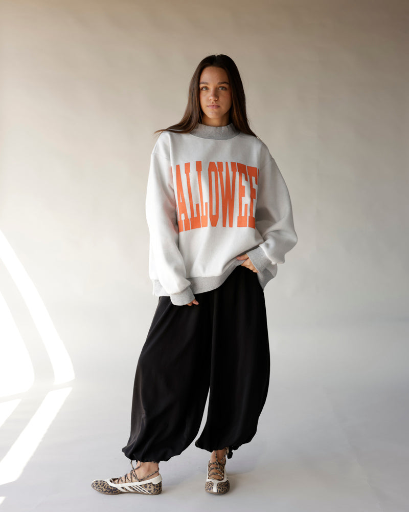 Oversized white mock neck sweatshirt with bold orange HALLOWEEN graphic print