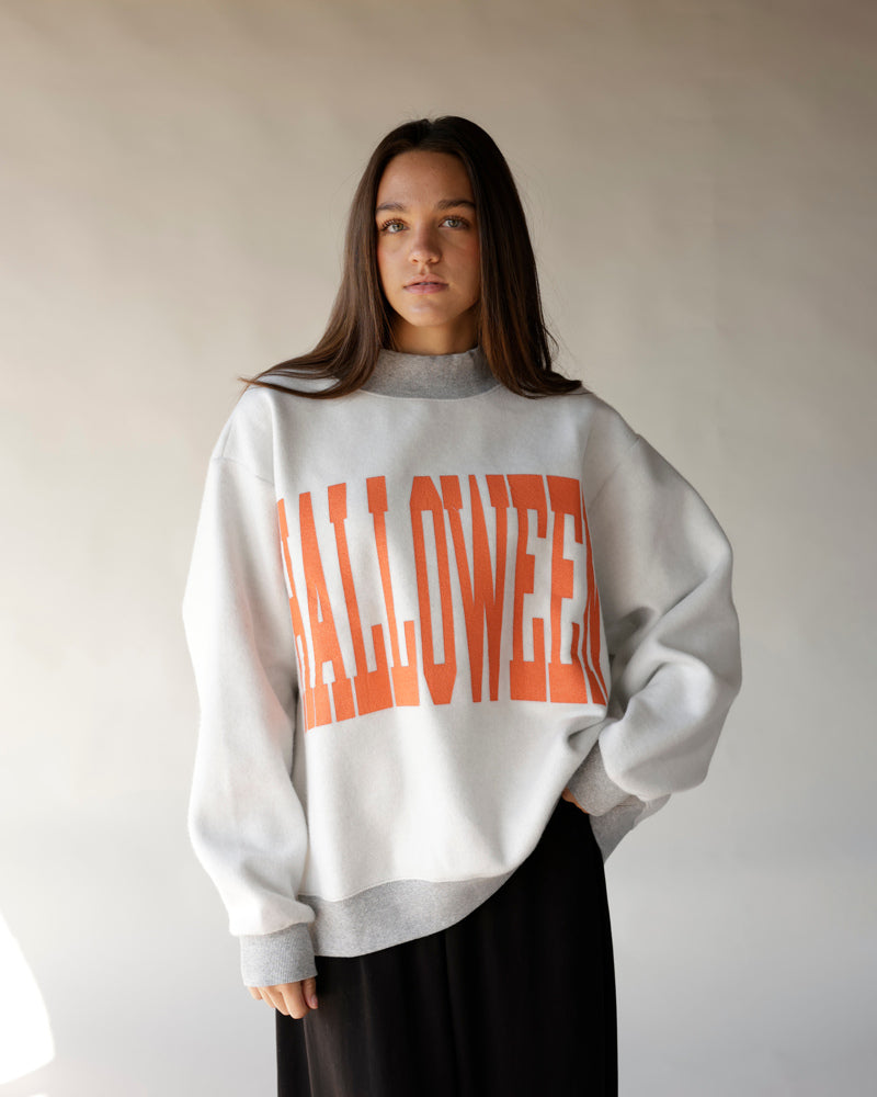 Oversized white Halloween reversible mock neck sweatshirt with bold orange graphic lettering