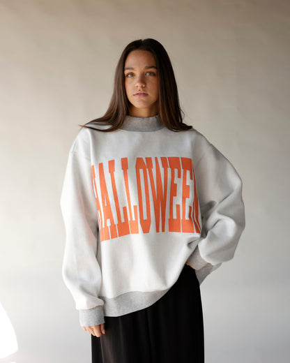 Oversized white Halloween reversible mock neck sweatshirt with bold orange graphic lettering