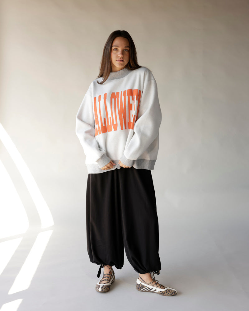 Oversized white mock neck sweatshirt with orange HALLOWEEN graphic print on front
