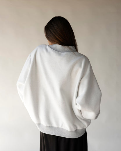 White reversible mock neck sweatshirt shown from back with gray ribbed hem