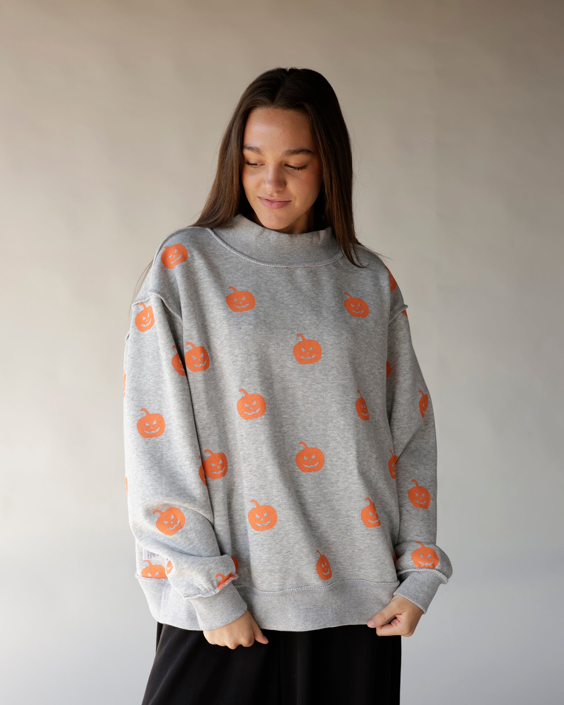 Gray mock neck sweatshirt with all-over orange jack-o-lantern pumpkin print