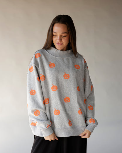 Gray mock neck sweatshirt with all-over orange jack-o-lantern pumpkin print