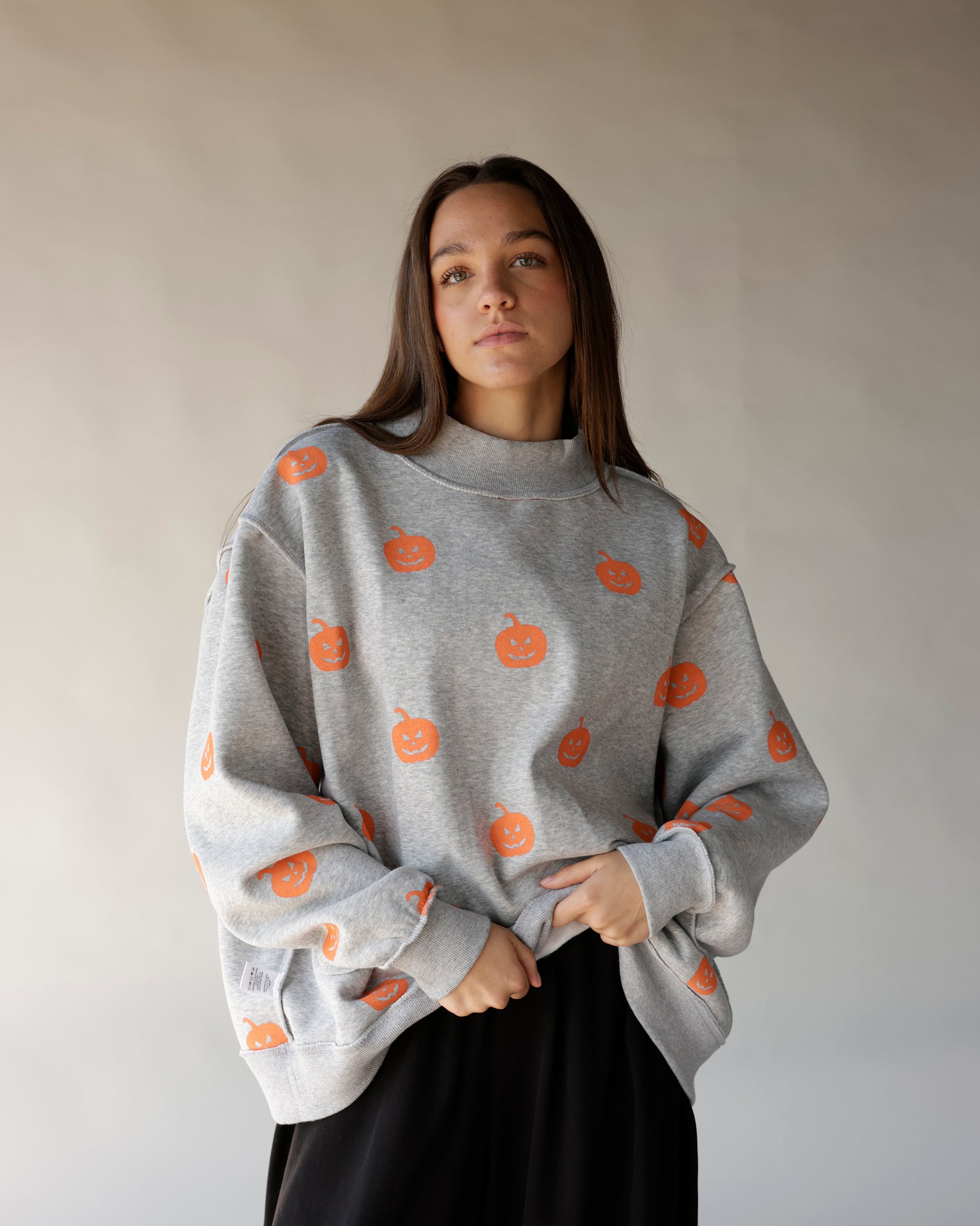Gray mock neck sweatshirt with allover orange jack-o-lantern pumpkin print