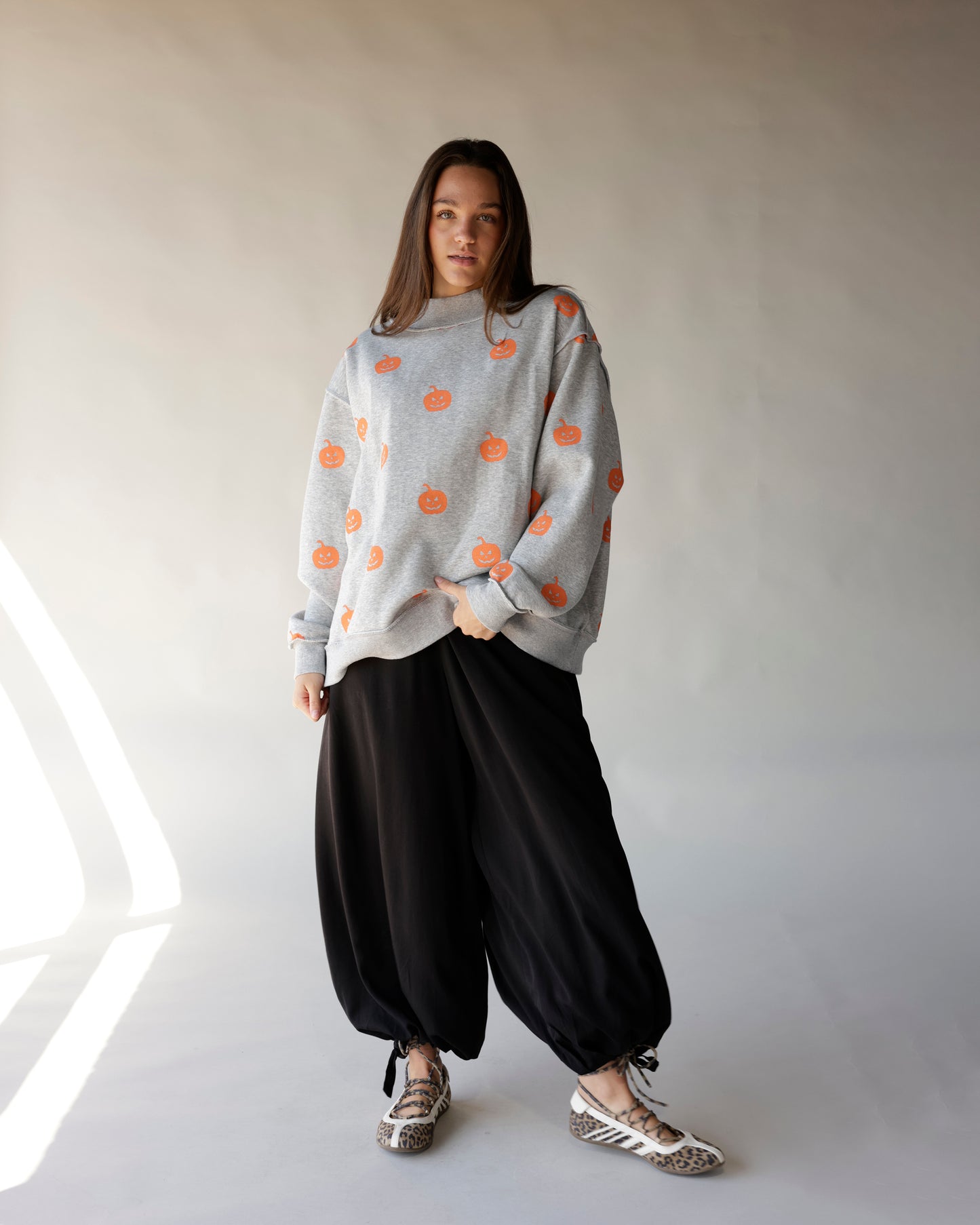 Gray oversized mock neck sweatshirt with orange jack-o-lantern pumpkin print allover pattern