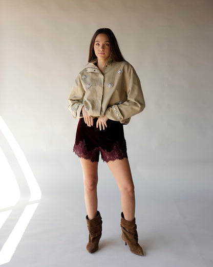 Maroon velvet shorts with scalloped lace hem trim, worn with beige jacket
