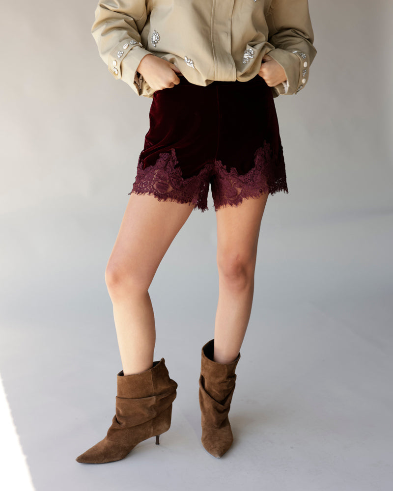 Maroon velvet shorts with lace hem trim, styled with brown suede ankle boots