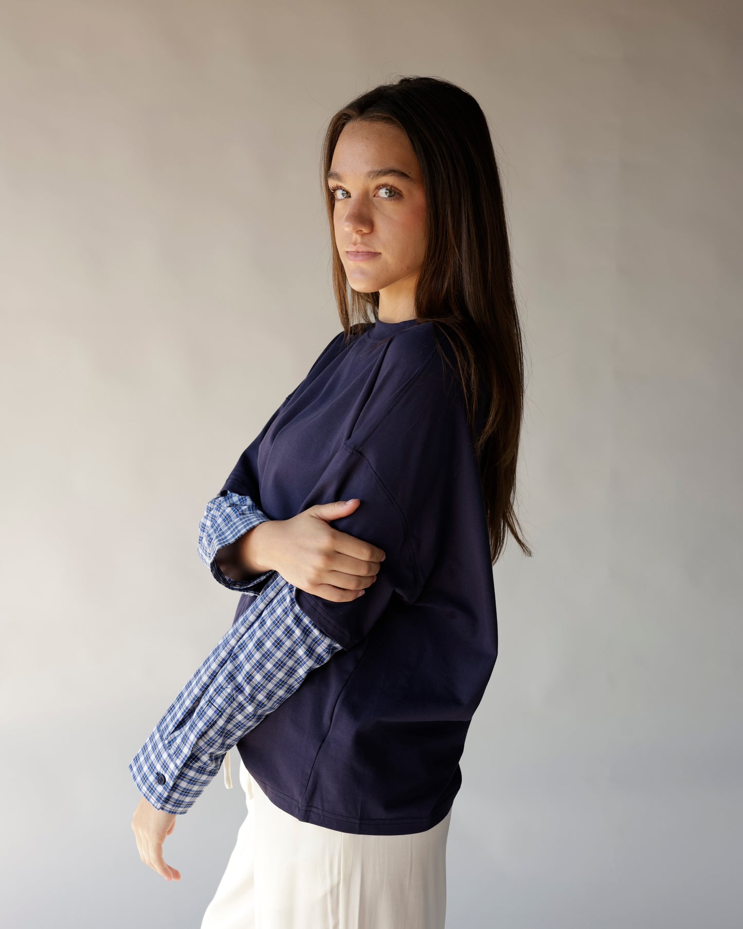 Oversized navy tee with blue plaid contrast sleeves, side view on model