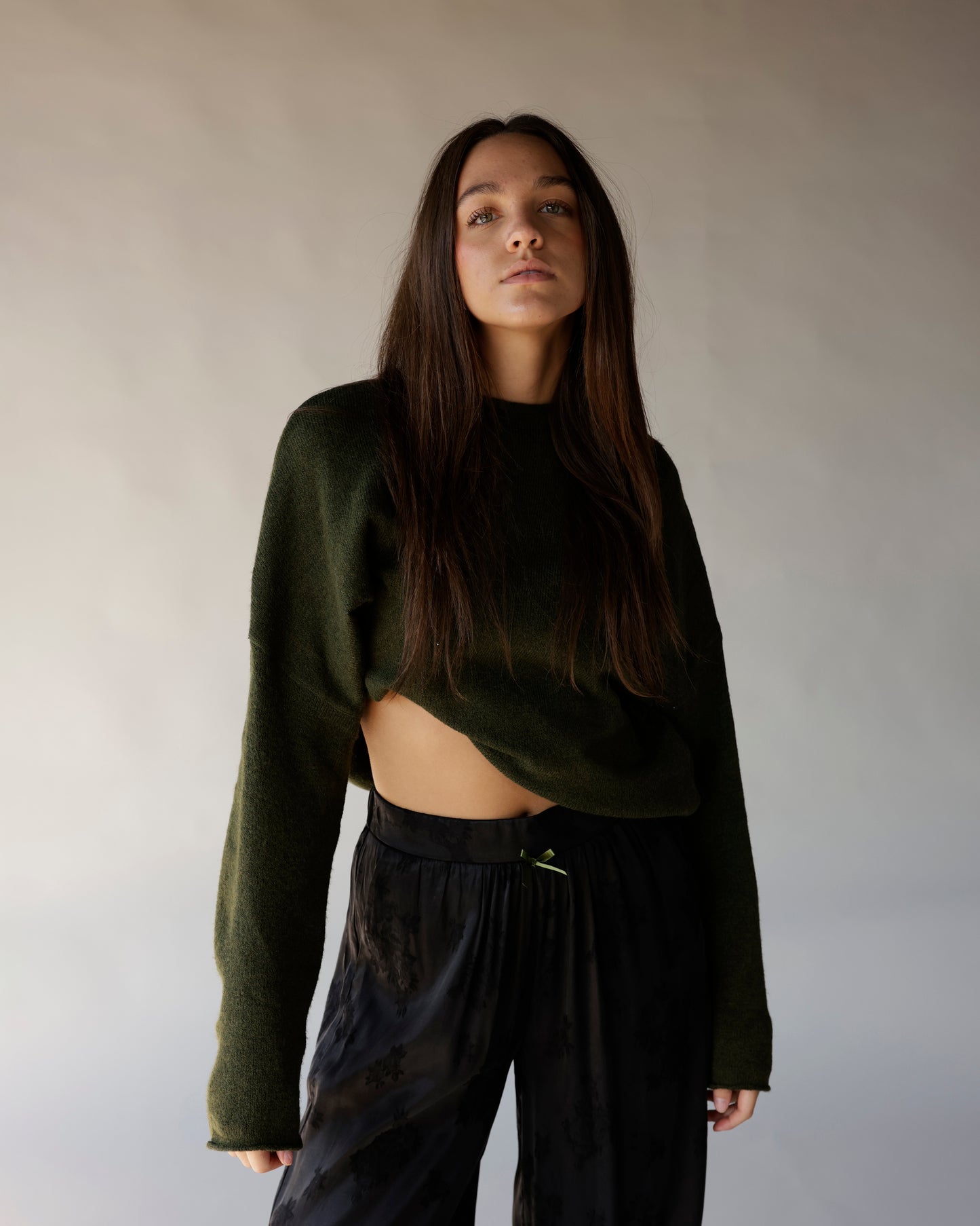 Dark olive green cropped mock neck knit sweater with long sleeves and open hem