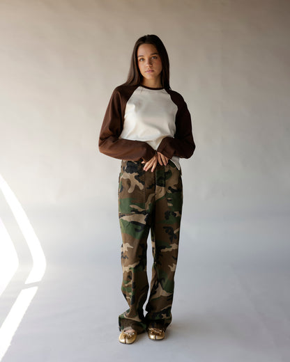 Brown and cream long sleeve raglan tee styled with camo wide-leg pants and gold flats.
