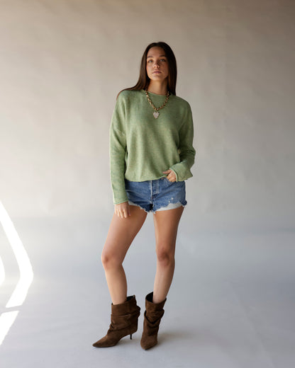Lemongrass green cropped mock neck sweater styled with denim cutoff shorts and brown boots