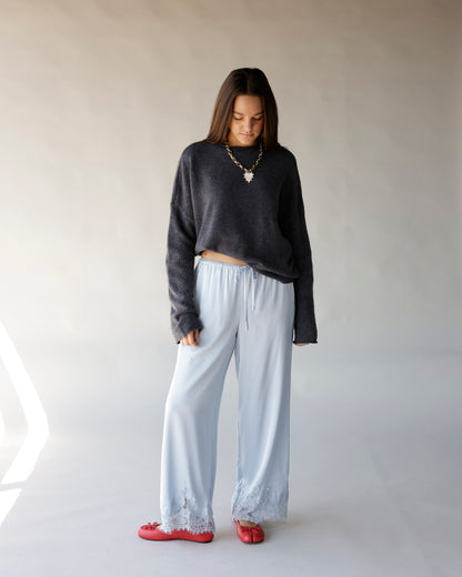 Dark gray cropped mock neck sweater with long sleeves, worn with light blue satin pants