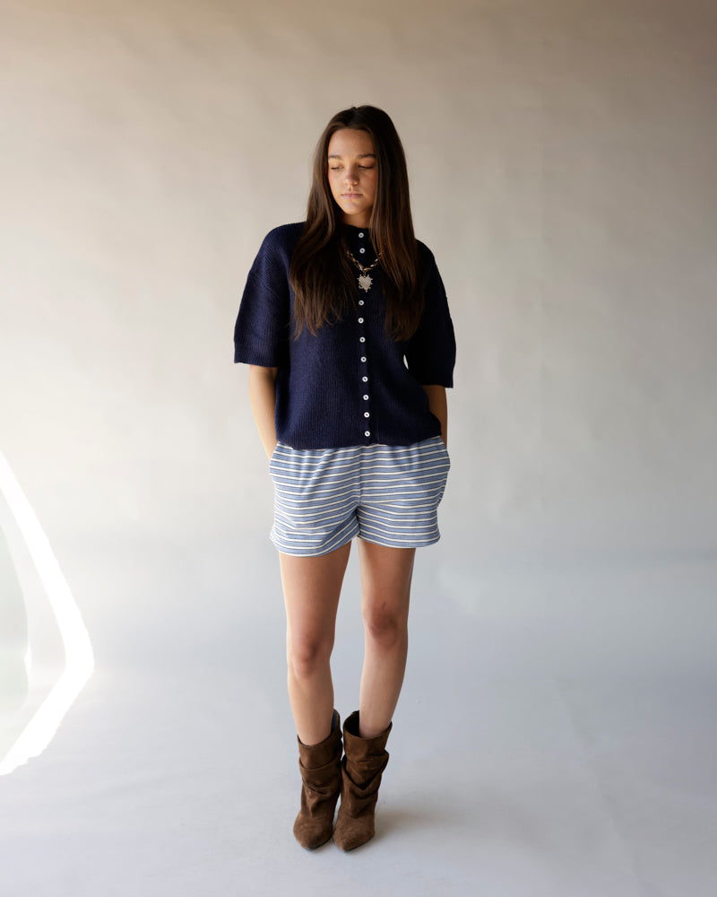 Navy short sleeve button-front knit cardigan worn with striped shorts and brown boots