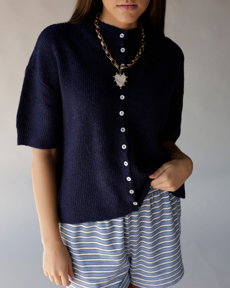 Navy blue short sleeve knit cardigan with white buttons and mock neck