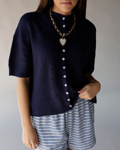 Navy blue short sleeve knit cardigan with white buttons and mock neck