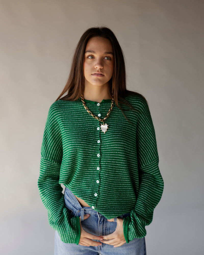 Green and white striped knit cardigan with white buttons, worn with jeans