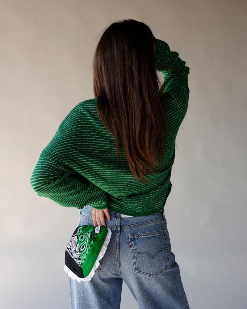 Green striped knit cardigan worn from back with light wash Levi's jeans