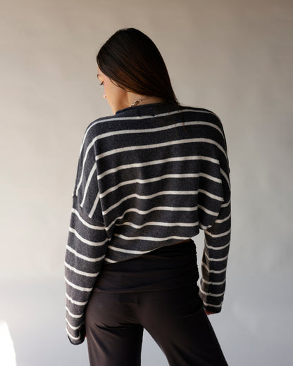 Cropped dark grey striped sweater with white horizontal stripes, long sleeves, back view