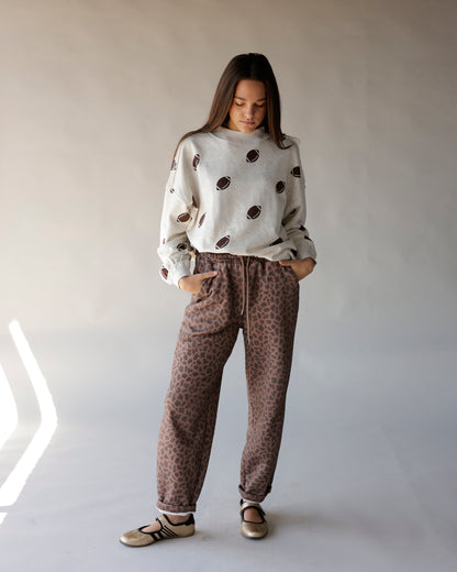 Cream mock neck sweatshirt with allover brown football print, relaxed fit
