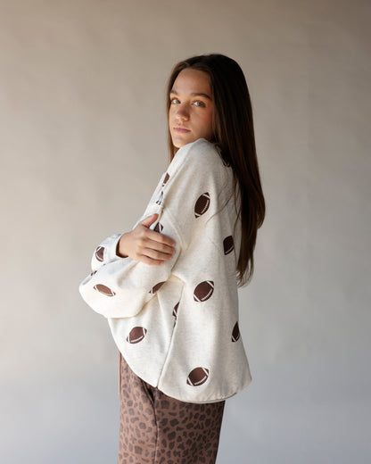 Cream mock neck sweatshirt with all-over football print, oversized fit
