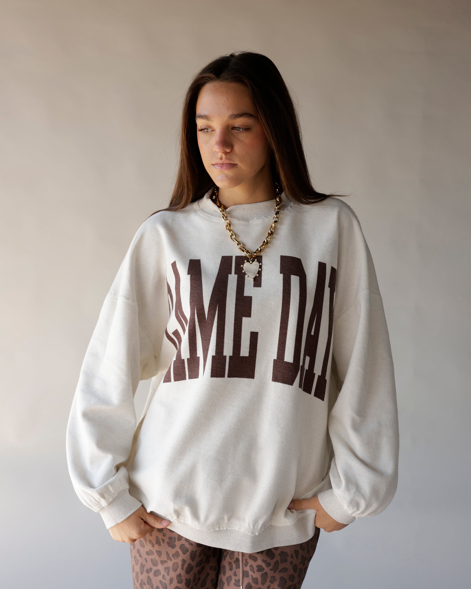 Cream mock neck sweatshirt with brown GAME DAY varsity graphic print on front