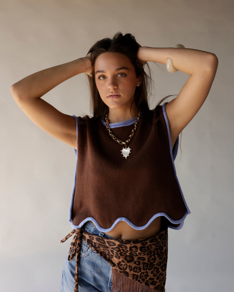 Brown cropped knit vest with lavender scallop trim worn over blue shirt