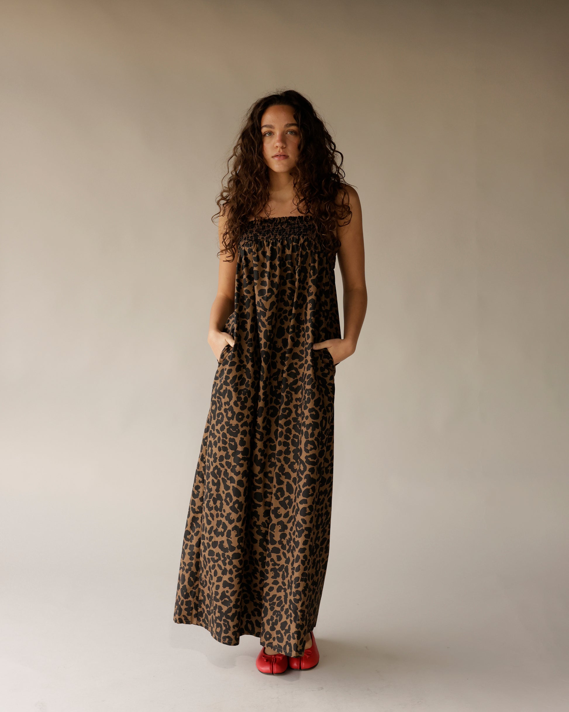 Leopard print strapless maxi dress with smocked bodice and pockets, styled with red flats.