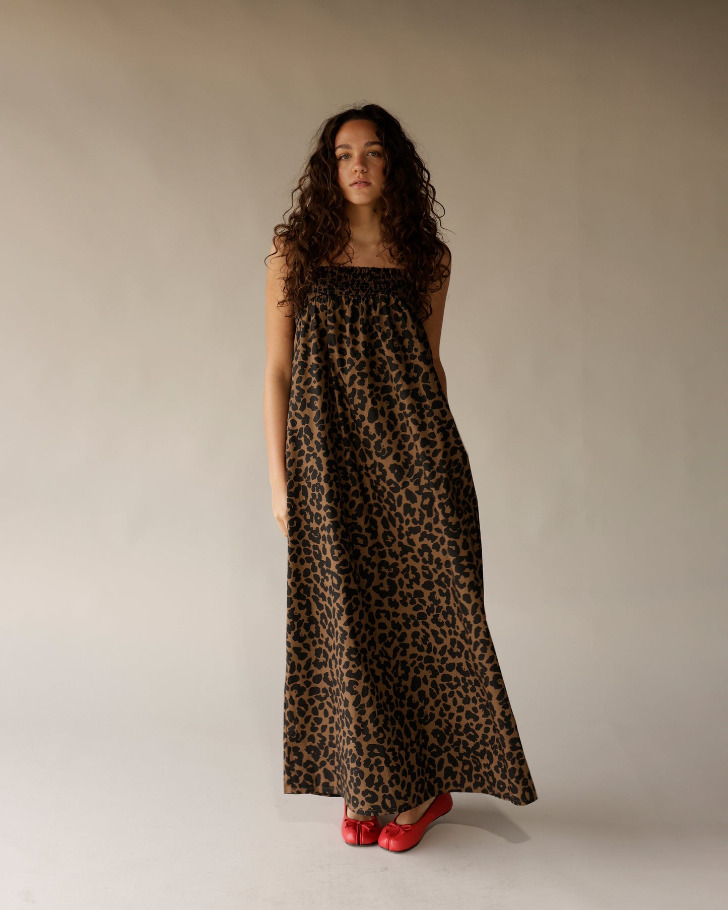 Leopard print strapless maxi dress with smocked bodice, worn with red ballet flats.