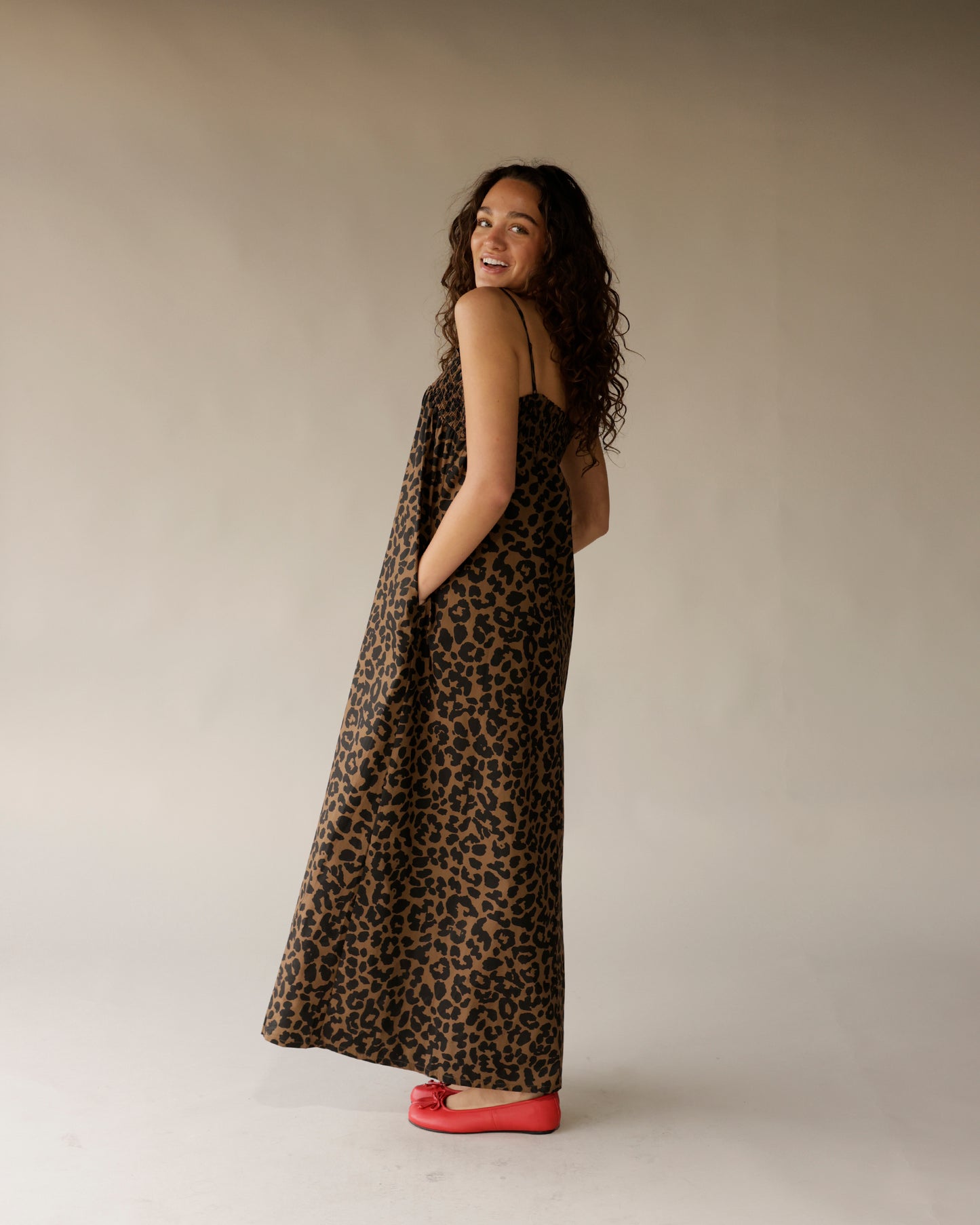 Leopard print maxi dress with thin straps, flowing silhouette, and side pockets