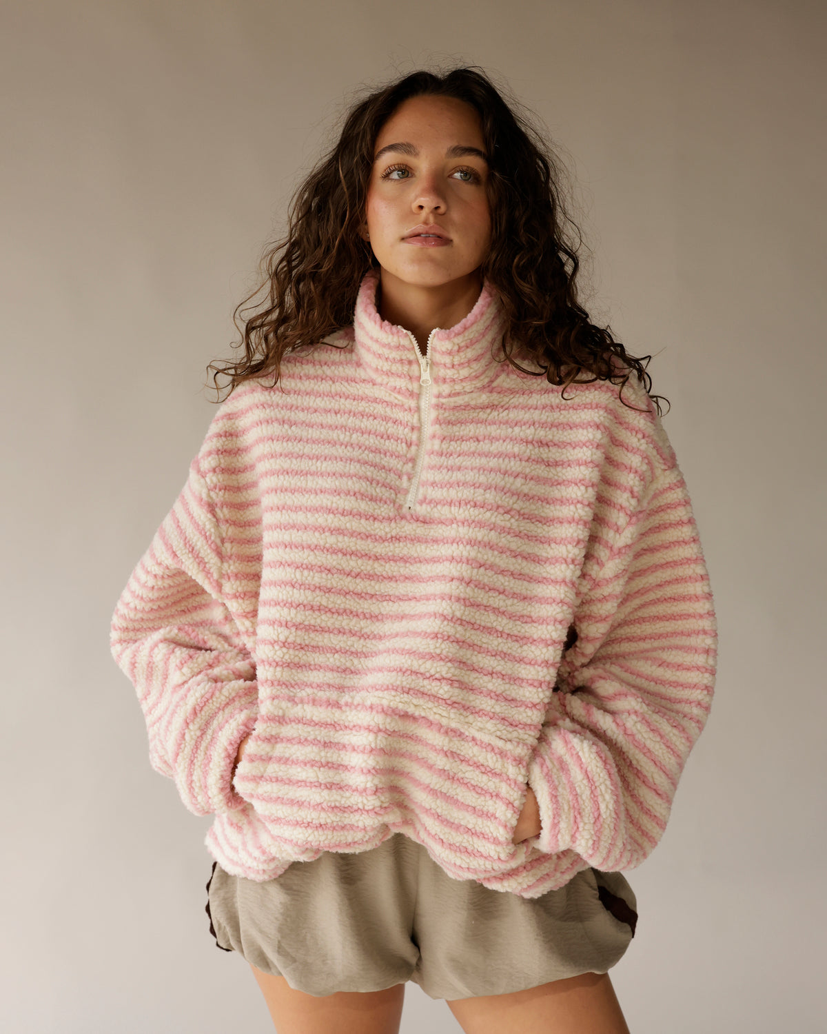 Pink and cream striped sherpa quarter-zip pullover with fleece texture and kangaroo pocket