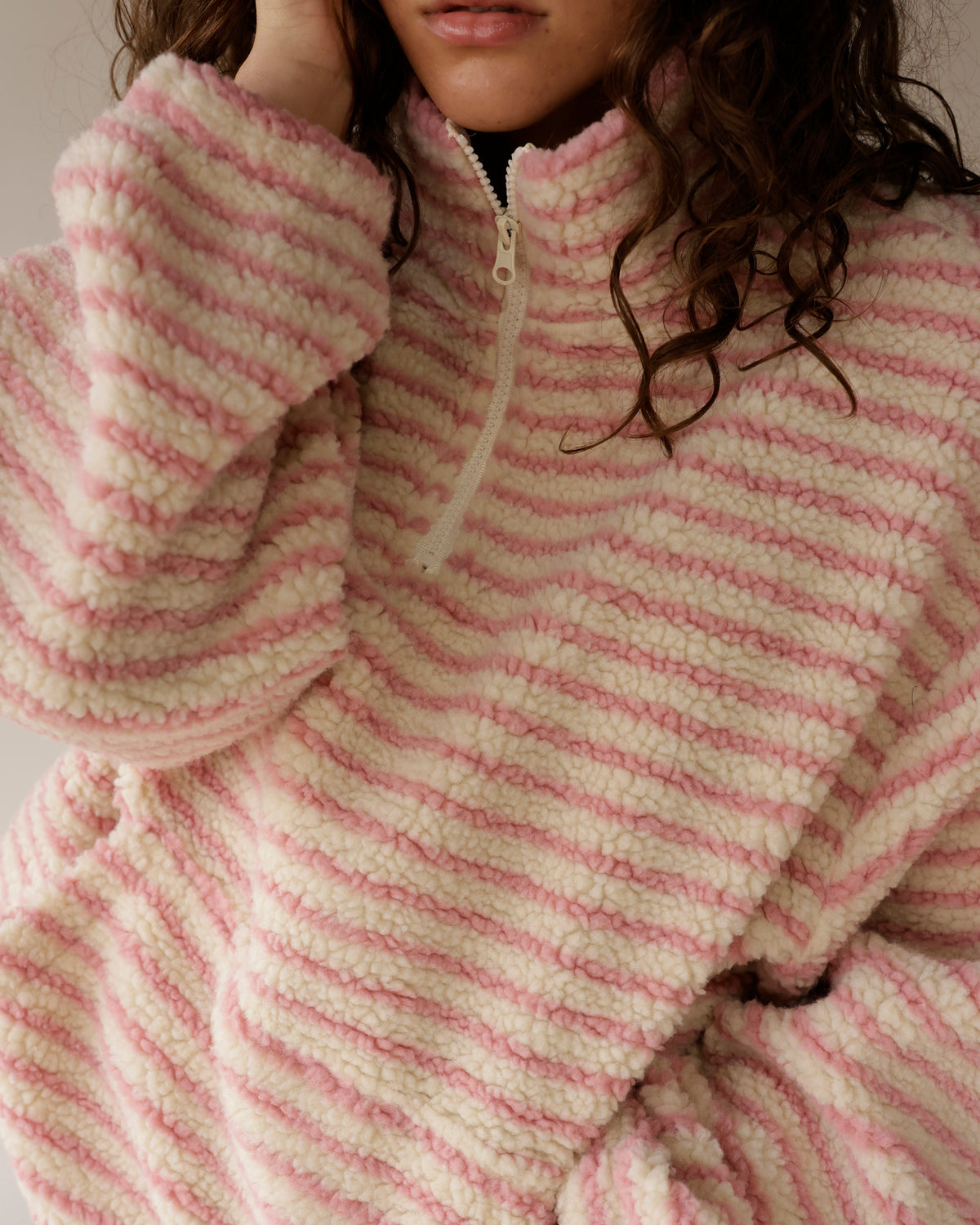 Pink and cream striped sherpa half-zip pullover with plush fleece texture